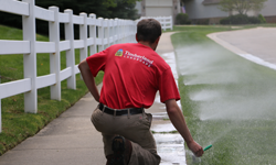 Photo of Timberland Landscape employee fixing a sprinkler system