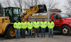 Photo of Timberland landscape employees standing in front of trucks